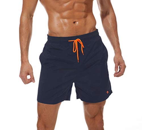 Hombre con bañador corto Tansozer color azul oscuro con cordón naranja, mostrando su musculatura y estilo.