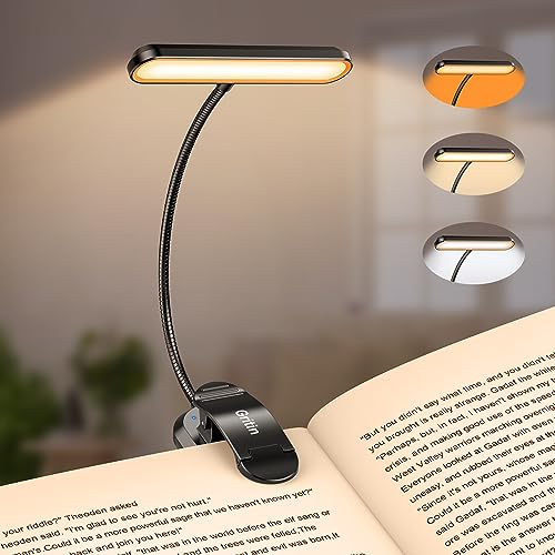 Lámpara de lectura con clip iluminando un libro, mostrando sus colores de luz cálido y blanco