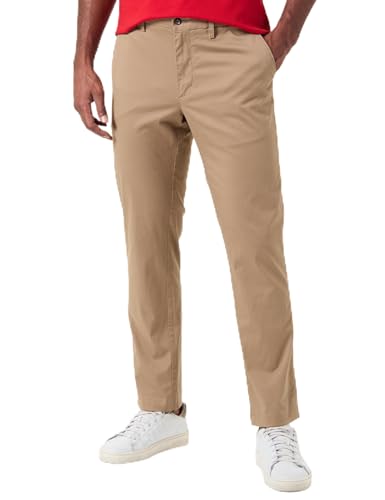 Pantalón chino masculino de Tommy Hilfiger en color beige, visto desde el frente, con un hombre posando con una camiseta roja y zapatillas blancas.