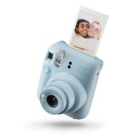 Cámara instantánea Instax Mini 12 en color azul pastel con una foto instantánea saliendo de la parte superior.