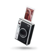Cámara instax Mini EVO en color negro con una foto impresa saliendo del dispositivo, mostrando el proceso de impresión instantánea.