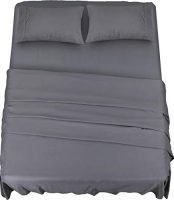 Juego de sábanas de microfibra gris suave y cómodo sobre una cama con almohadas.