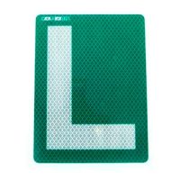 Imagen de la placa L reflectante de color verde, diseñada para conductores noveles, mostrando su forma y textura.