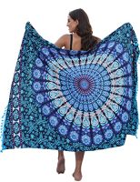 Mujer sosteniendo un pareo de gasa con diseño mandala en colores azul y turquesa, ideal para la playa
